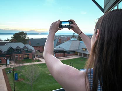 Student taking a picture of Lake Champlain