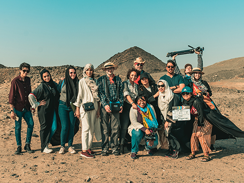 students on a film set in a desert