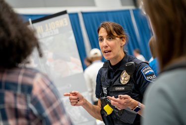 Police officer speaks with students at bi-annual Career Fair.