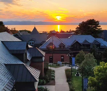 View across campus to sun setting over Lake Champlain