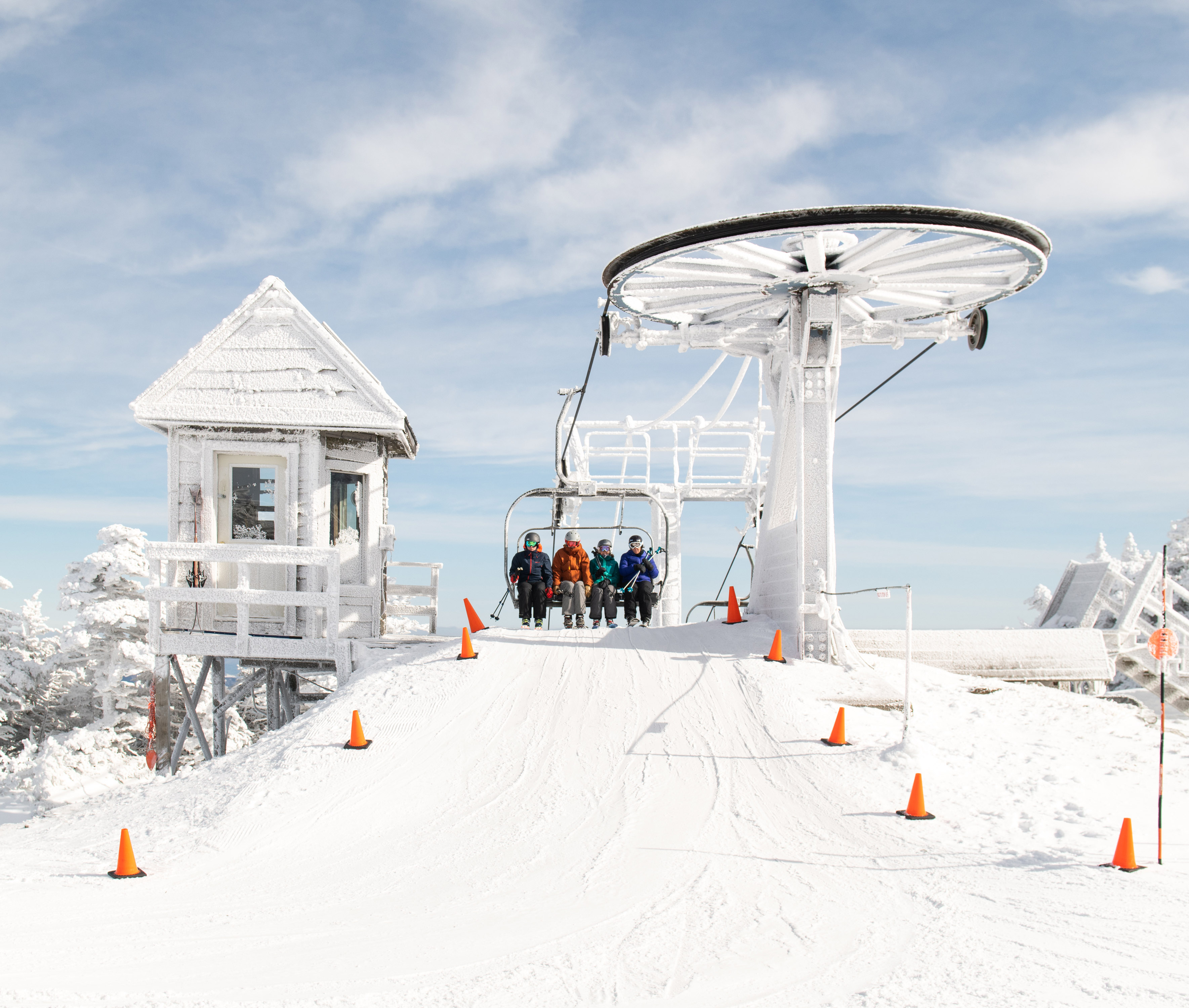 Students riding a ski lift covered in a fresh coat of snow