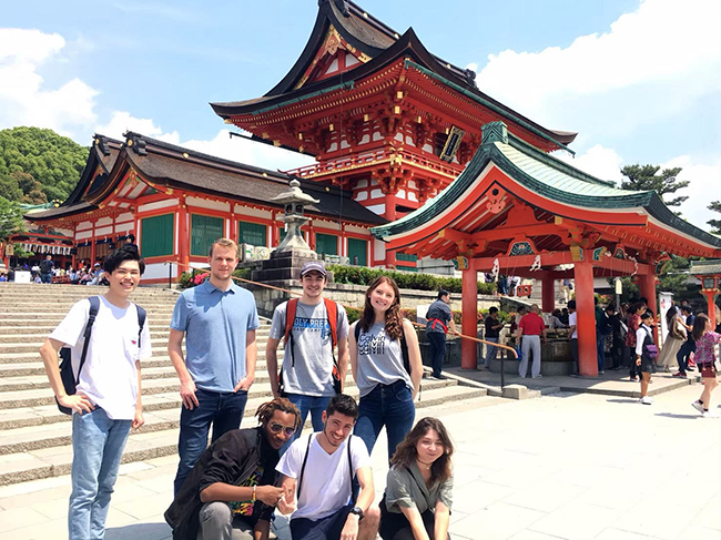 students in Kyoto gather for group photo near traditional buildings