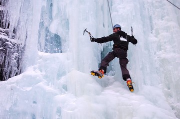 A student ice climbing on wall of ice