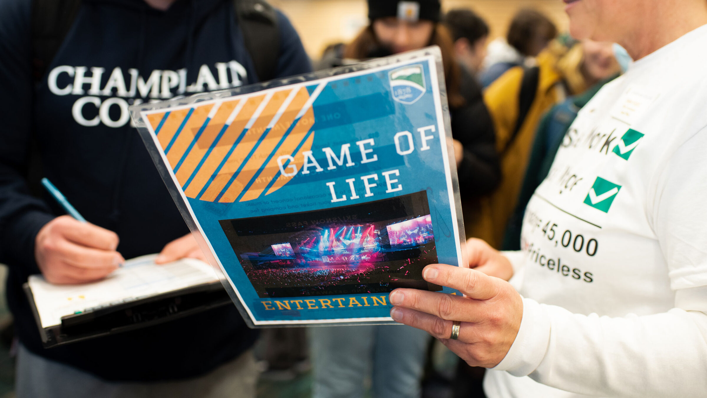 Two people collaborating and looking at a flyer that says "Game of Life"