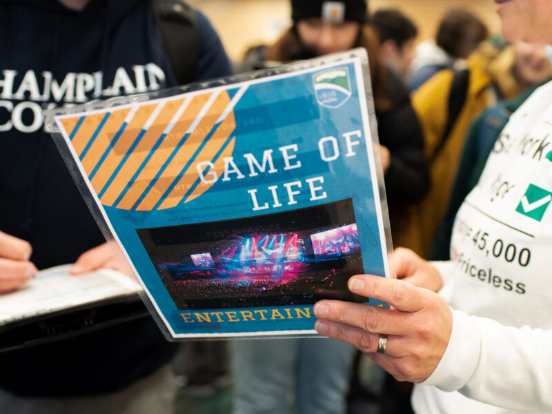 Two people collaborating and looking at a flyer that says "Game of Life"