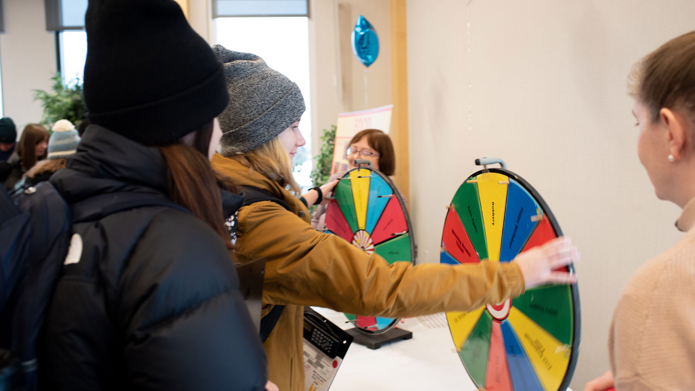 Students spin a wheel of life's surprises as they play Game of Life.