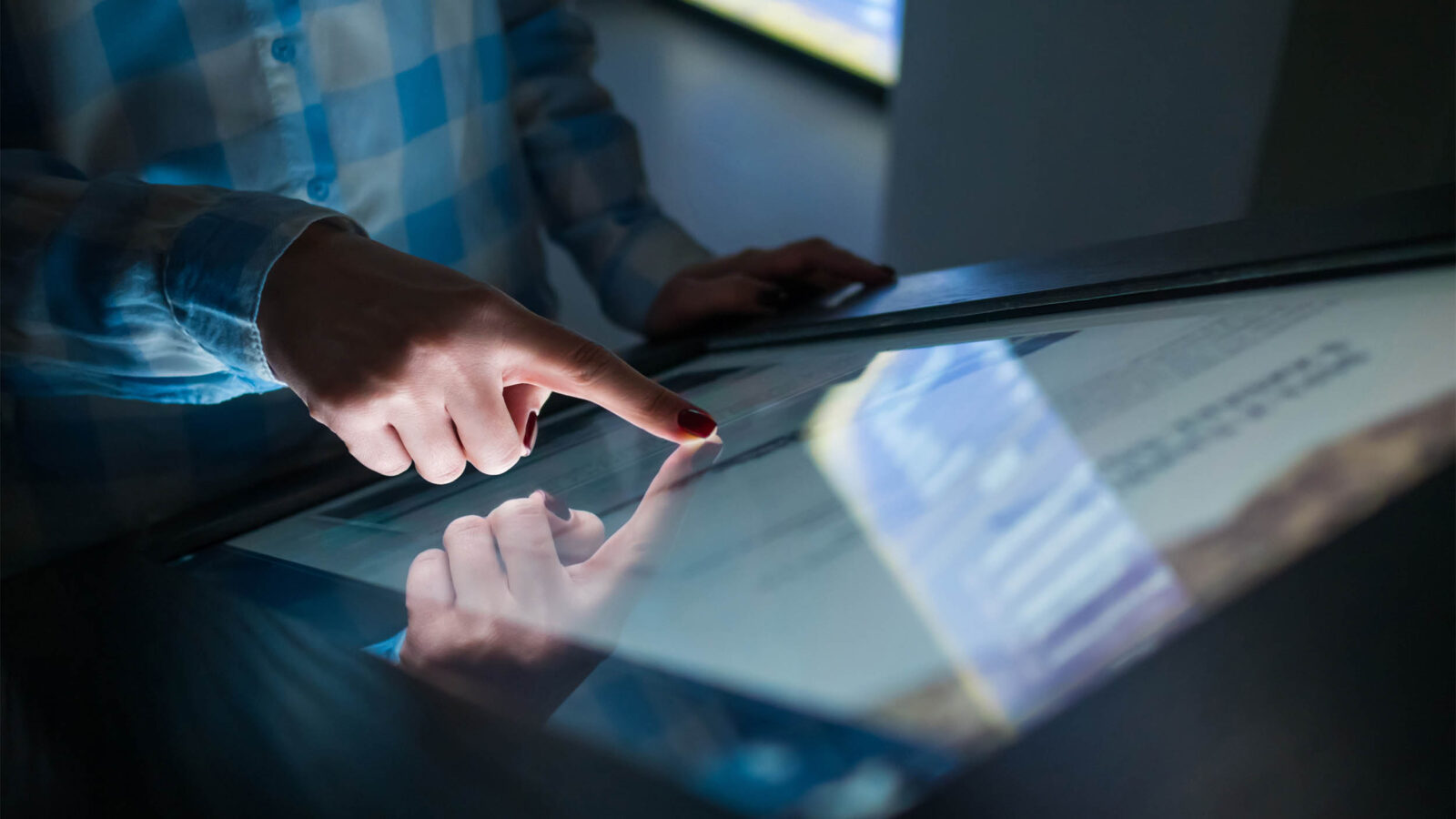 close up view of woman hand using interactive touchscreen display of electronic kiosk at modern museum or exhibition - scrolling and touching