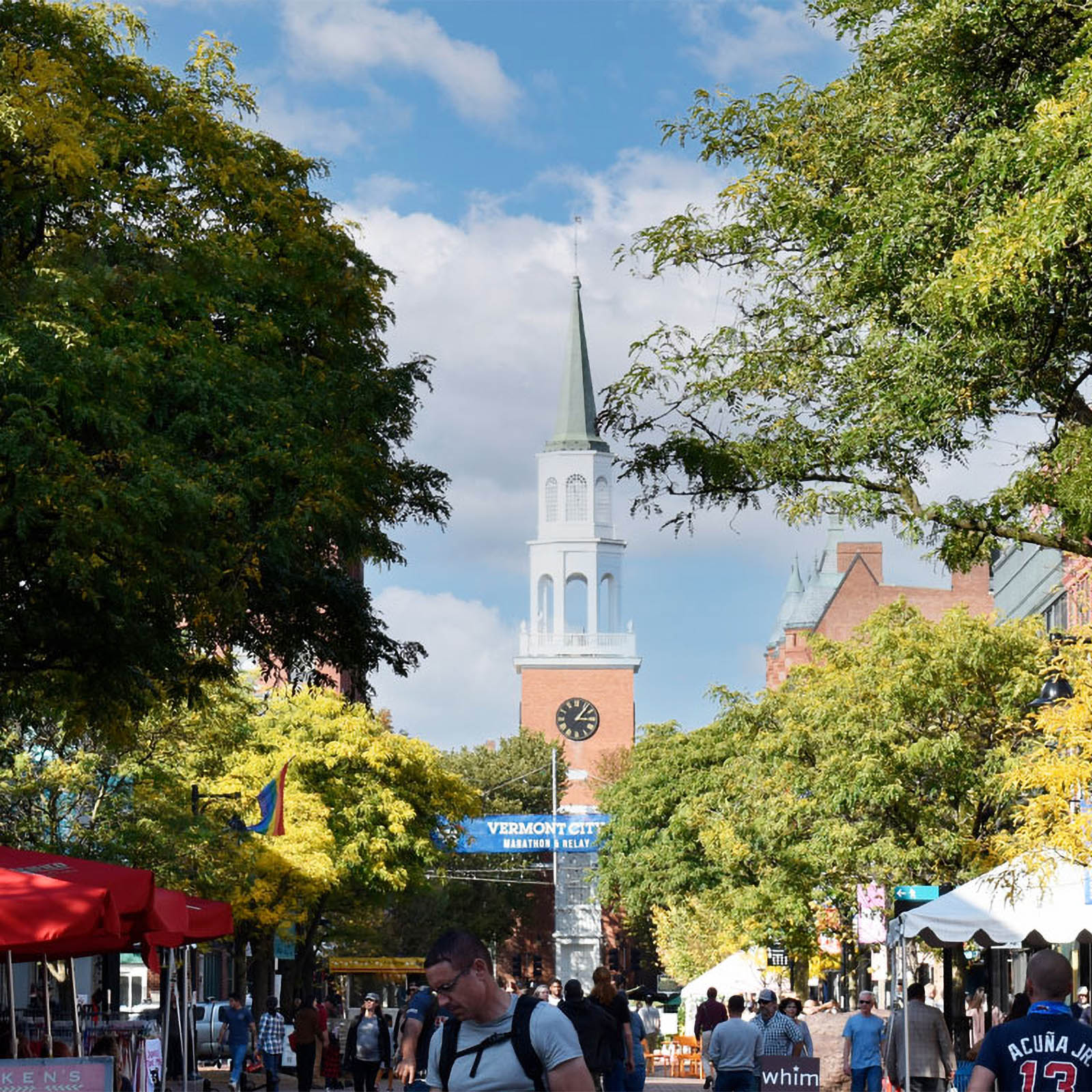a church steeple rises above the crowd on church street in burlington, vermont