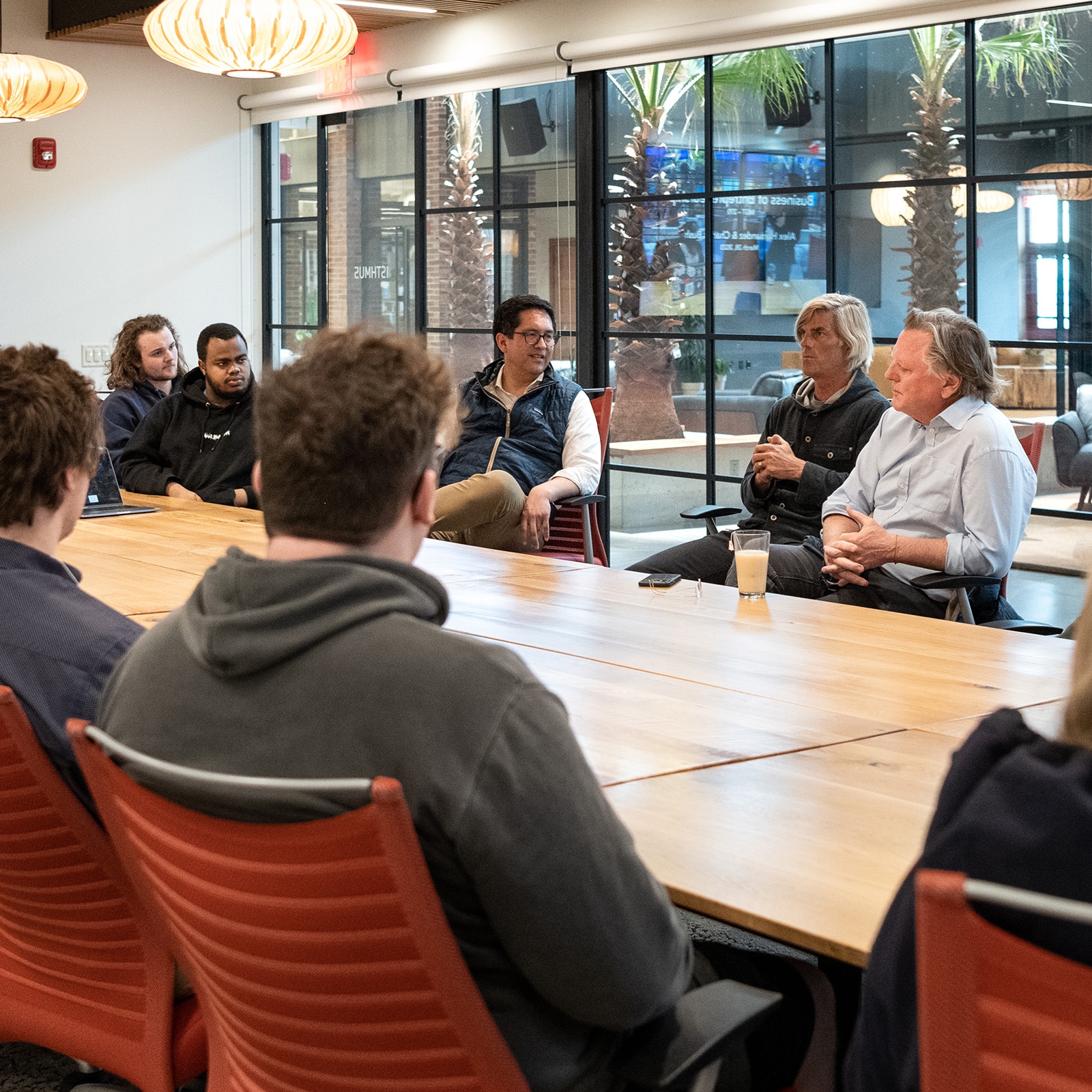 people meet and talk around a large conference table