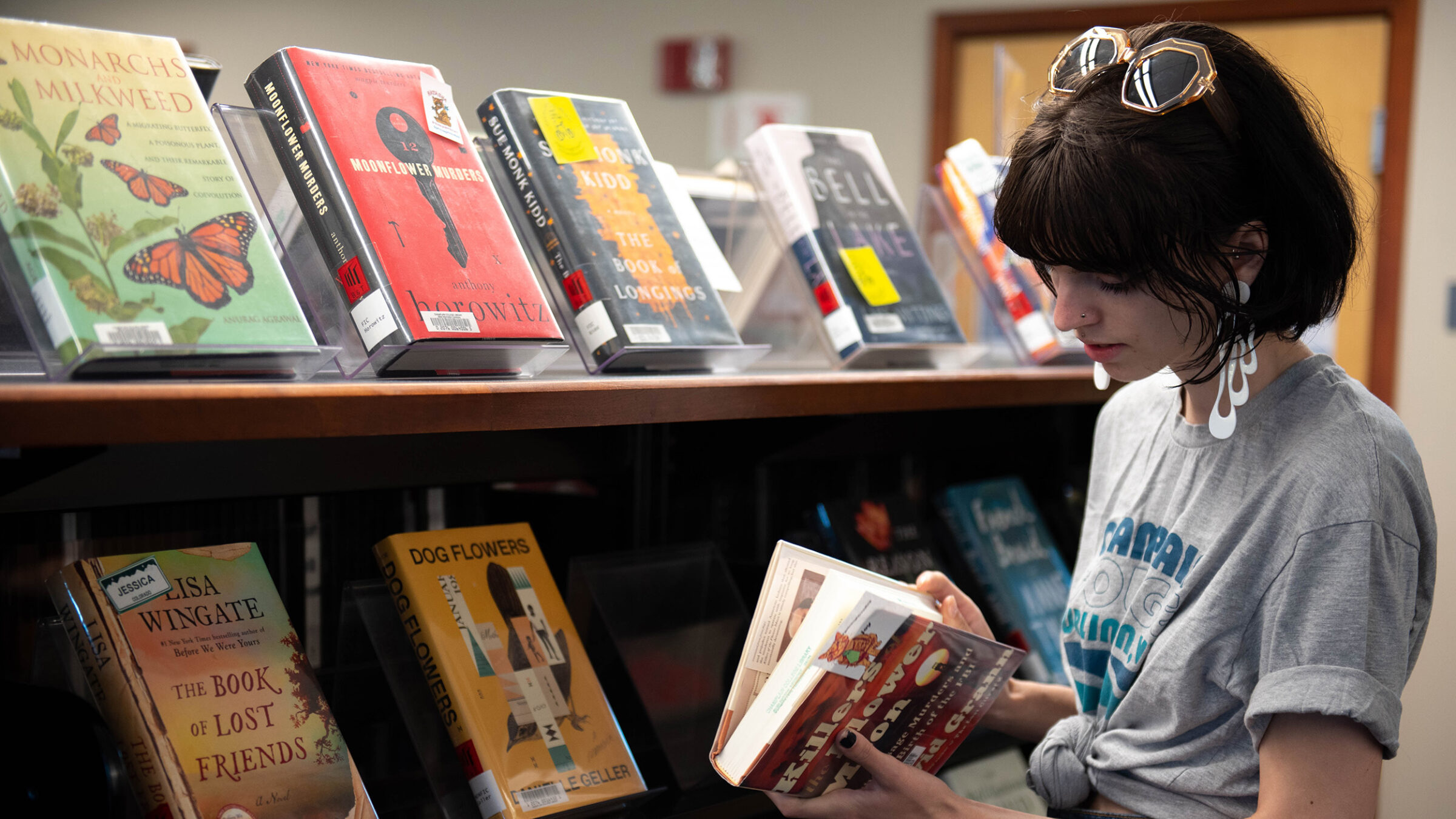 student chooses book from the library shelf