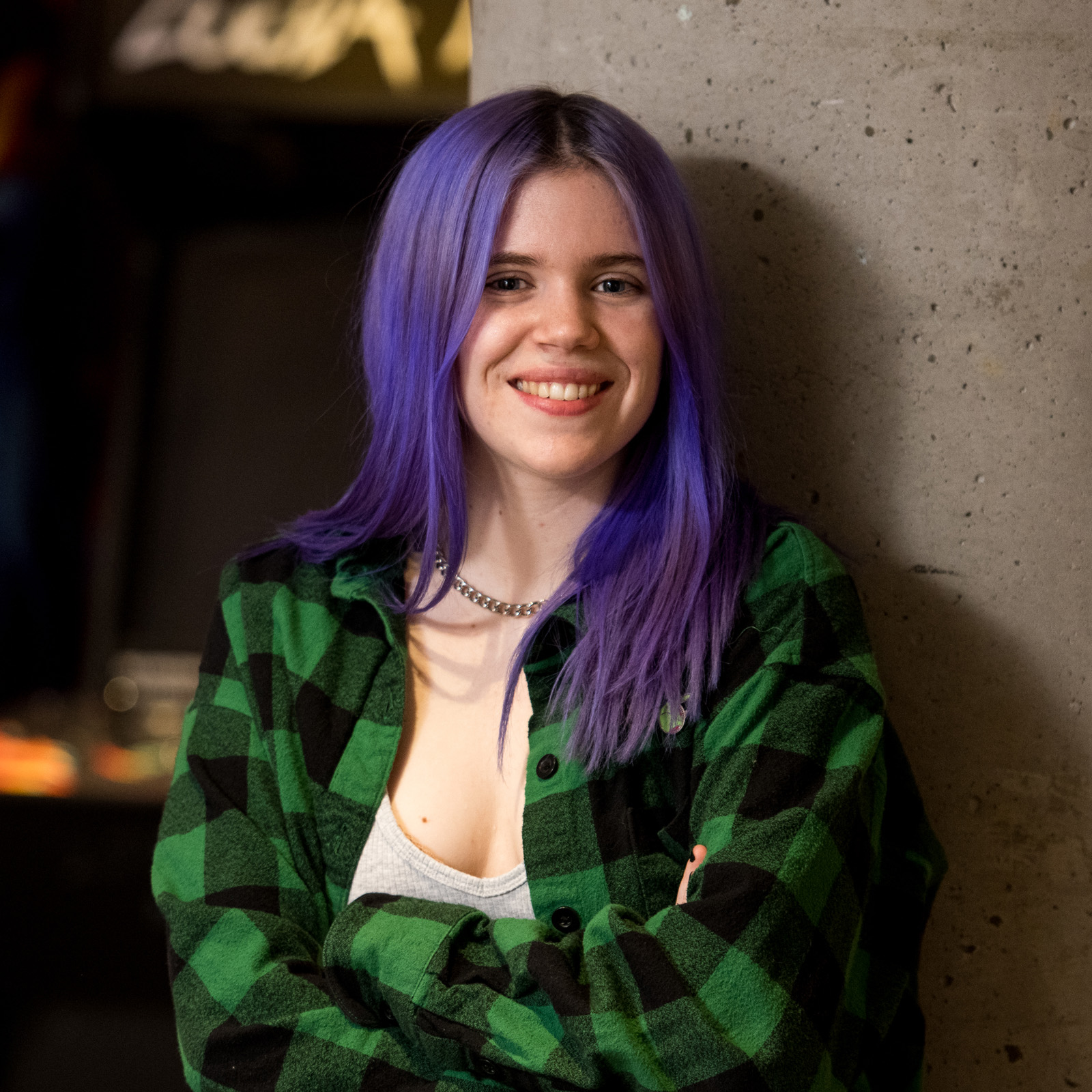 student with long purple hair smiling at camera