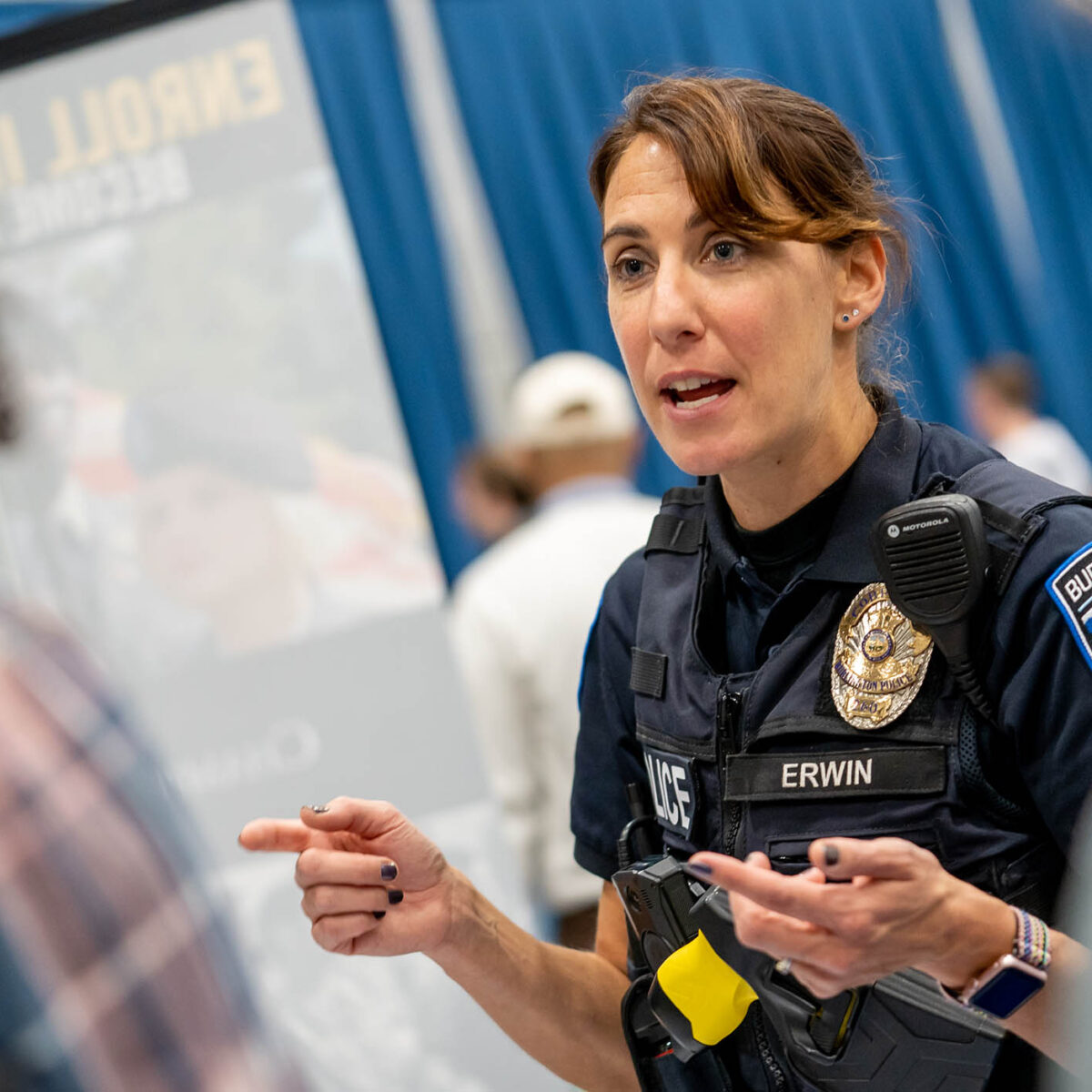 a police officer speaks to students at a career fair