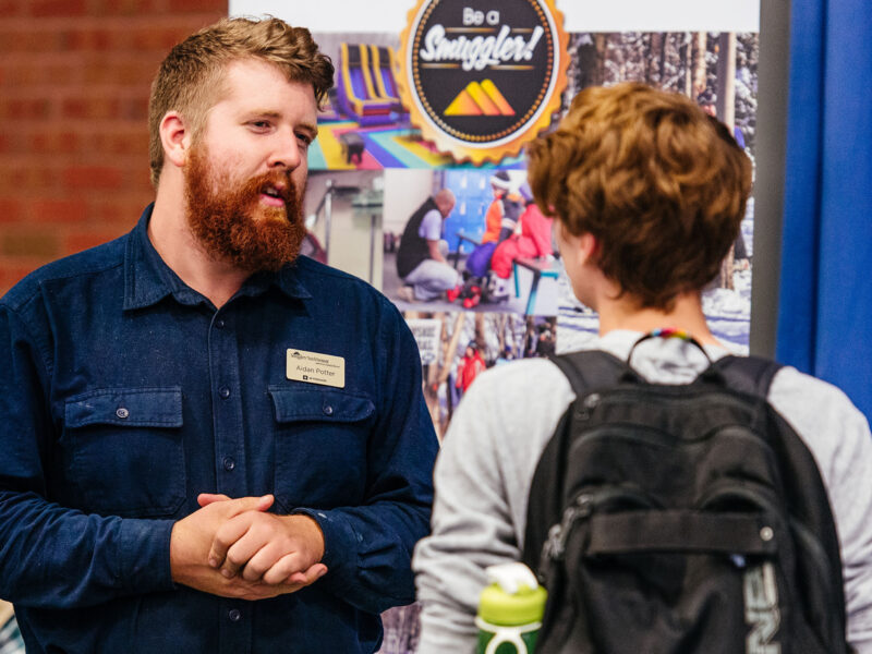 student talks with a smugglers notch representative at a career fair