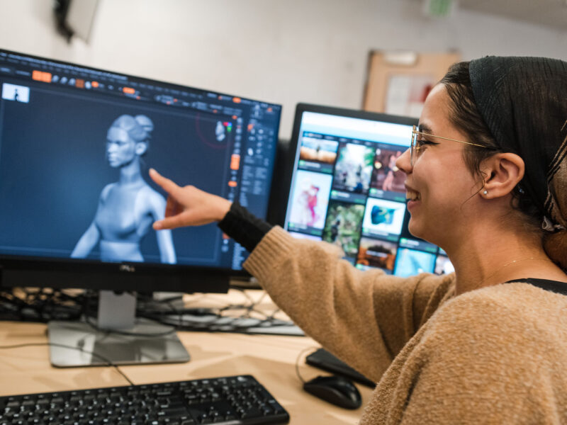 game art student pointing at a character model design on their screen