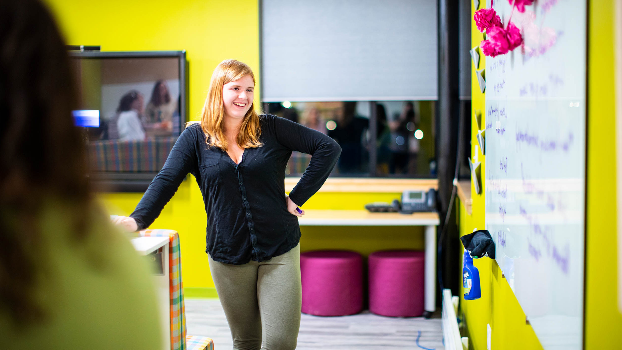 student surveys her work written out on a white board