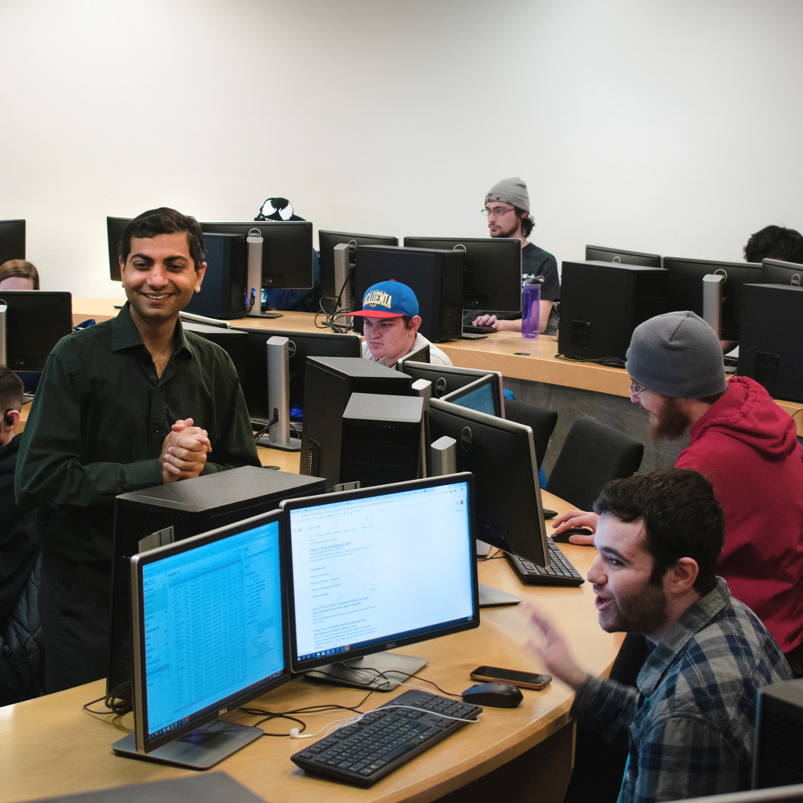 students using computers smiling with professor
