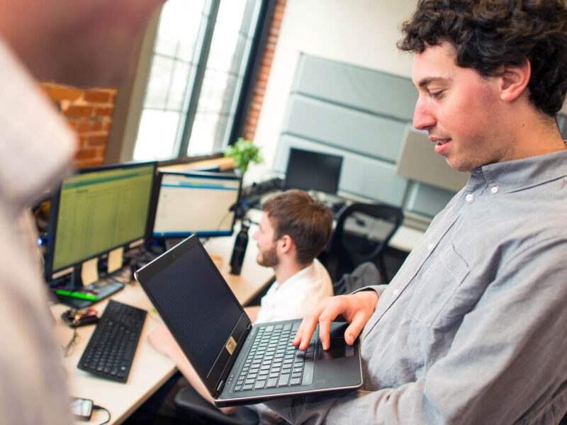 a computer science major working on a laptop in a professional environment