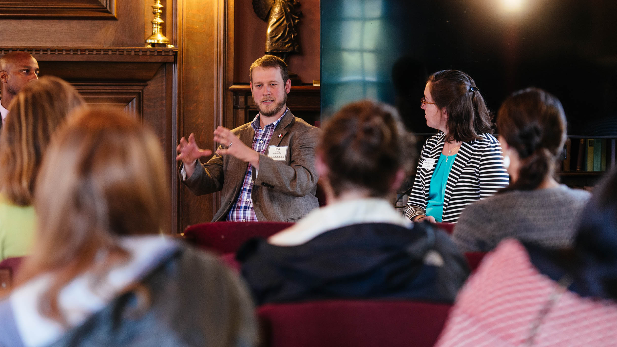 seated speakers talk to a group of conference attendees