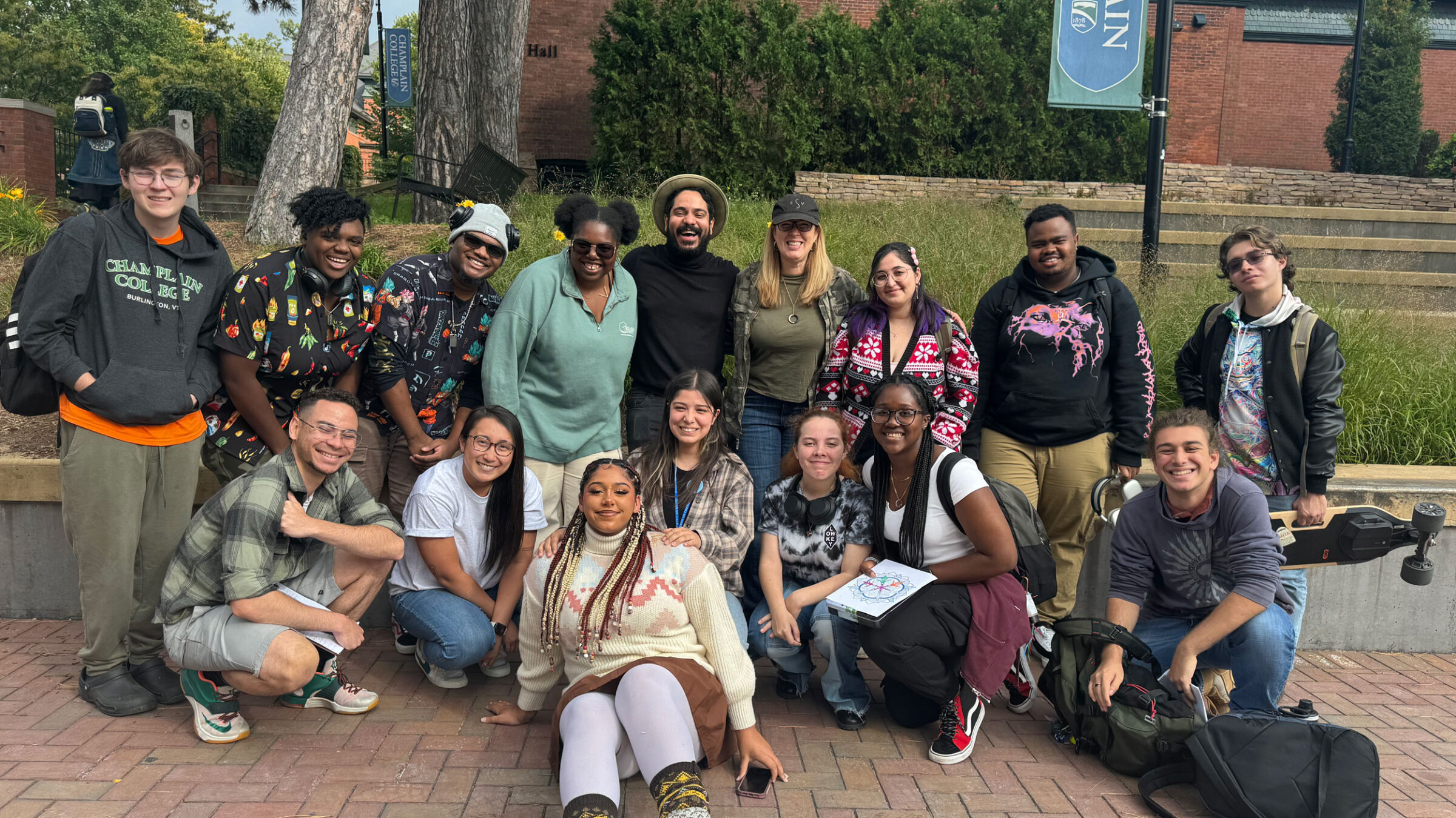 a group of about 20 students smile at the camera in the courtyard alongside musician gustavo moradel