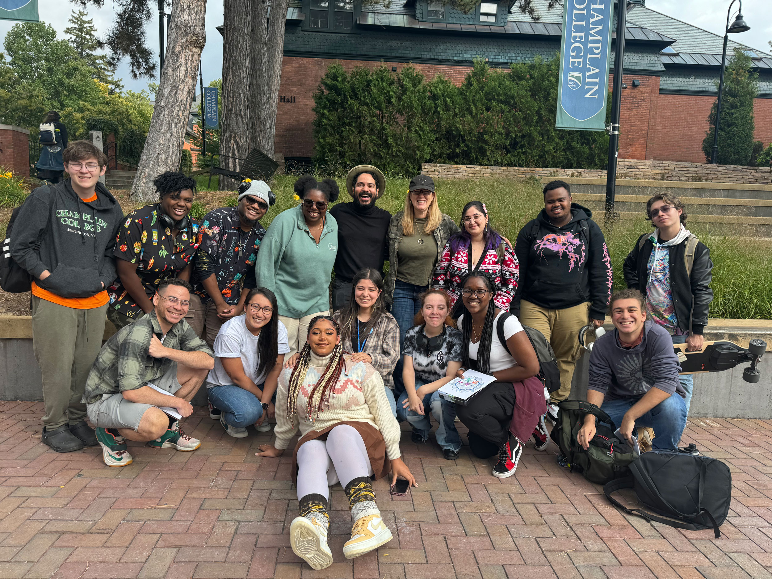 a group of about 20 students smile at the camera in the courtyard alongside musician gustavo moradel