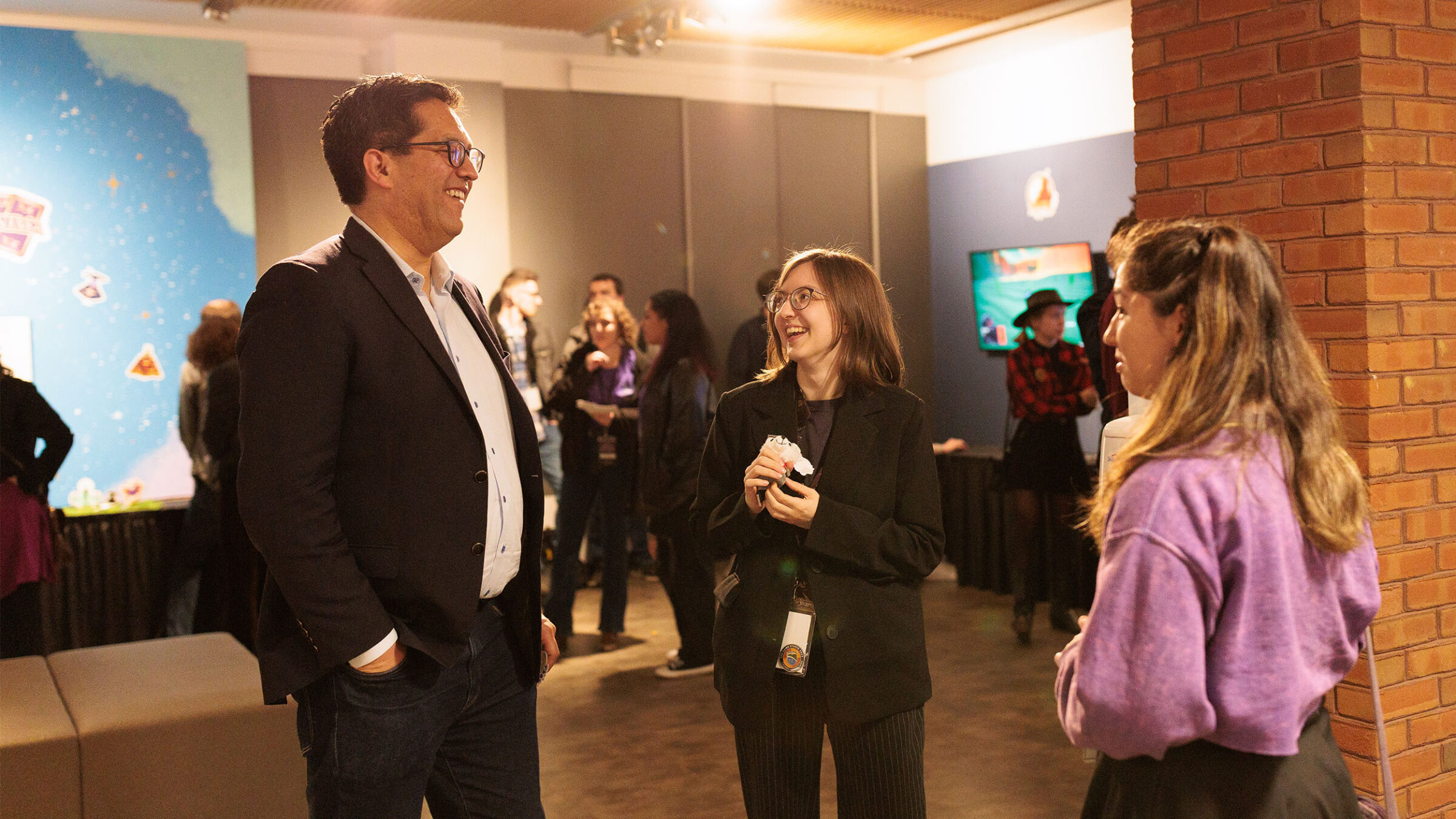 game studio student chatting with president alex hernandez at the game studio senior show reception event