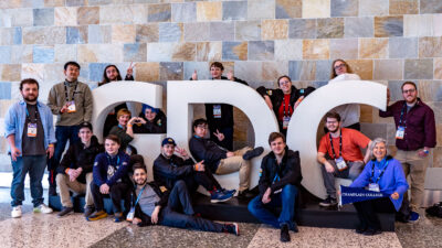 champlain college game studio students posing for a photo with the GDC sign at the game developers conference