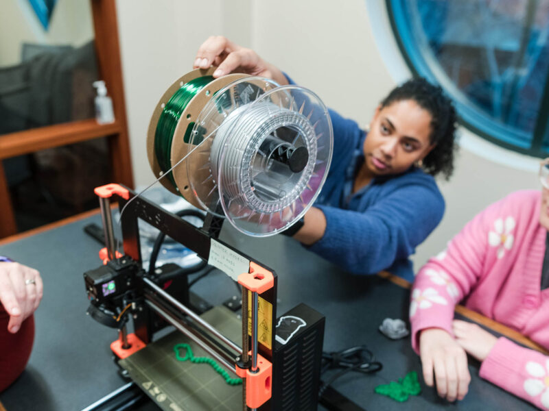 students operating a 3D printer