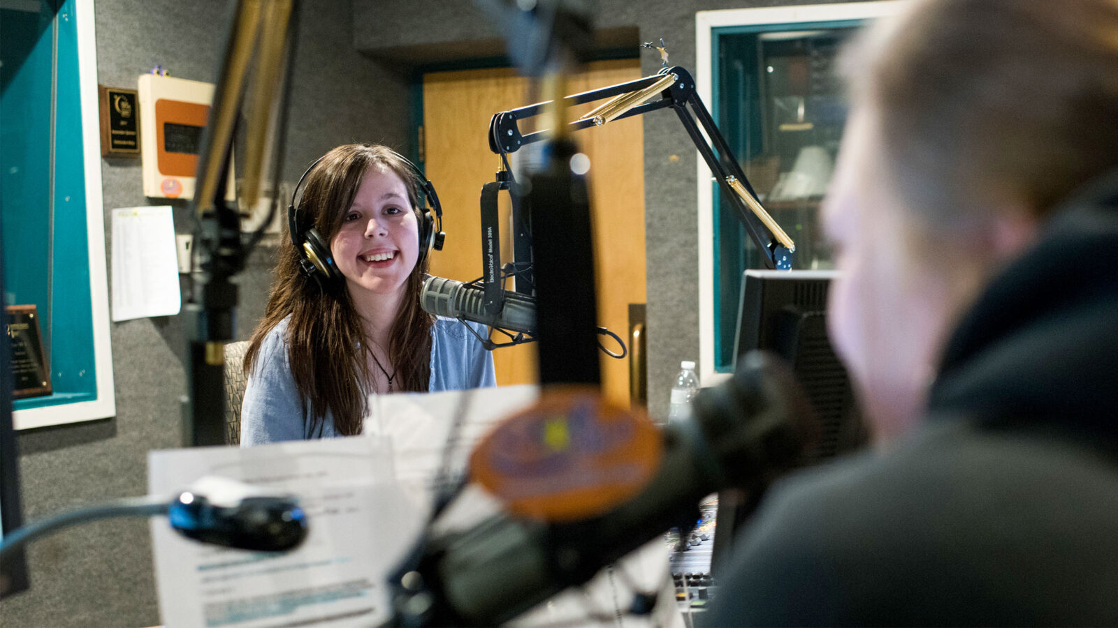 broadcast media student recording audio from a professional sound booth