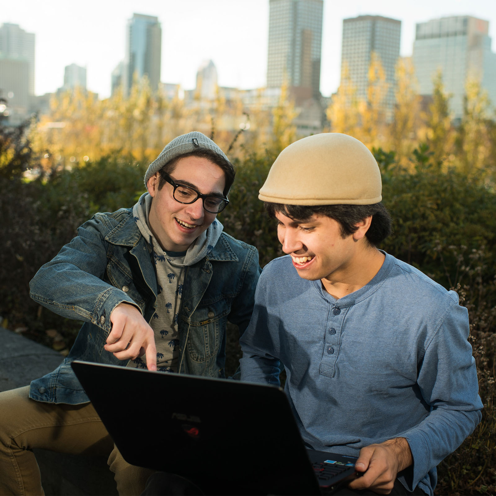 two abroad students looking at a laptop outside in montreal