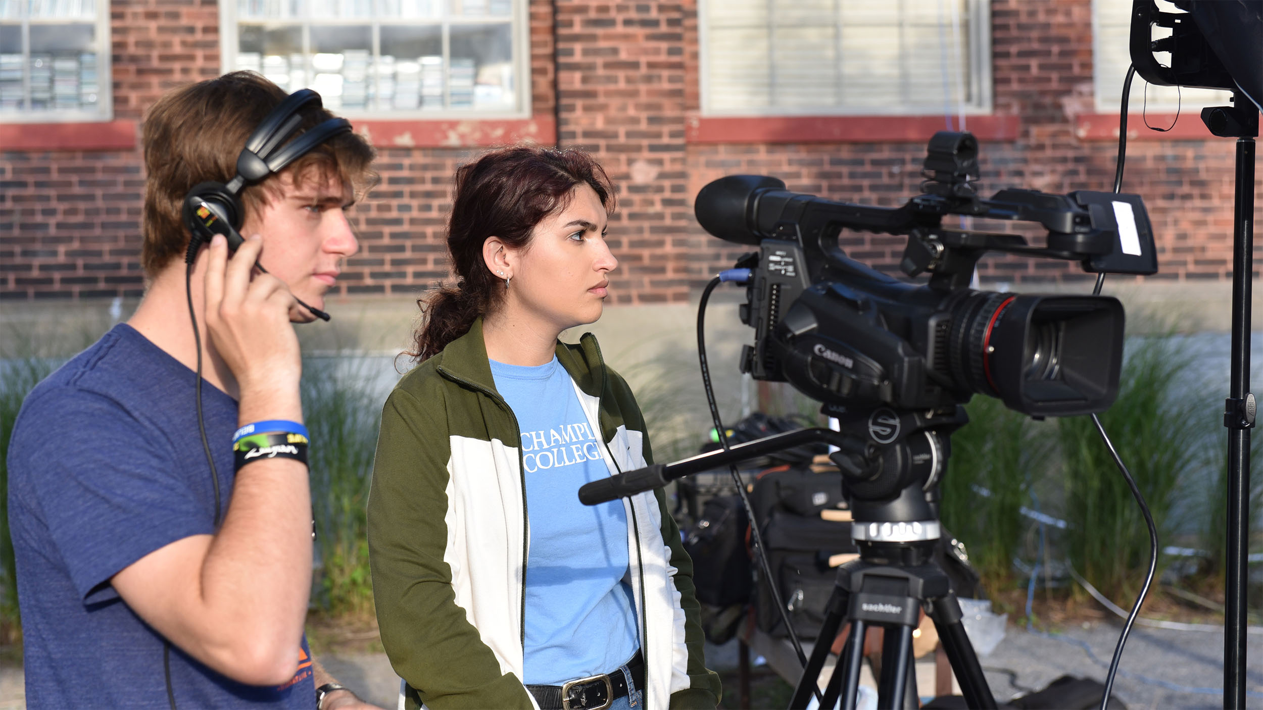 two students, one with a headphone the other with a broadcast camera