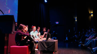 a group of game studio students unveiling their new game at the senior game show