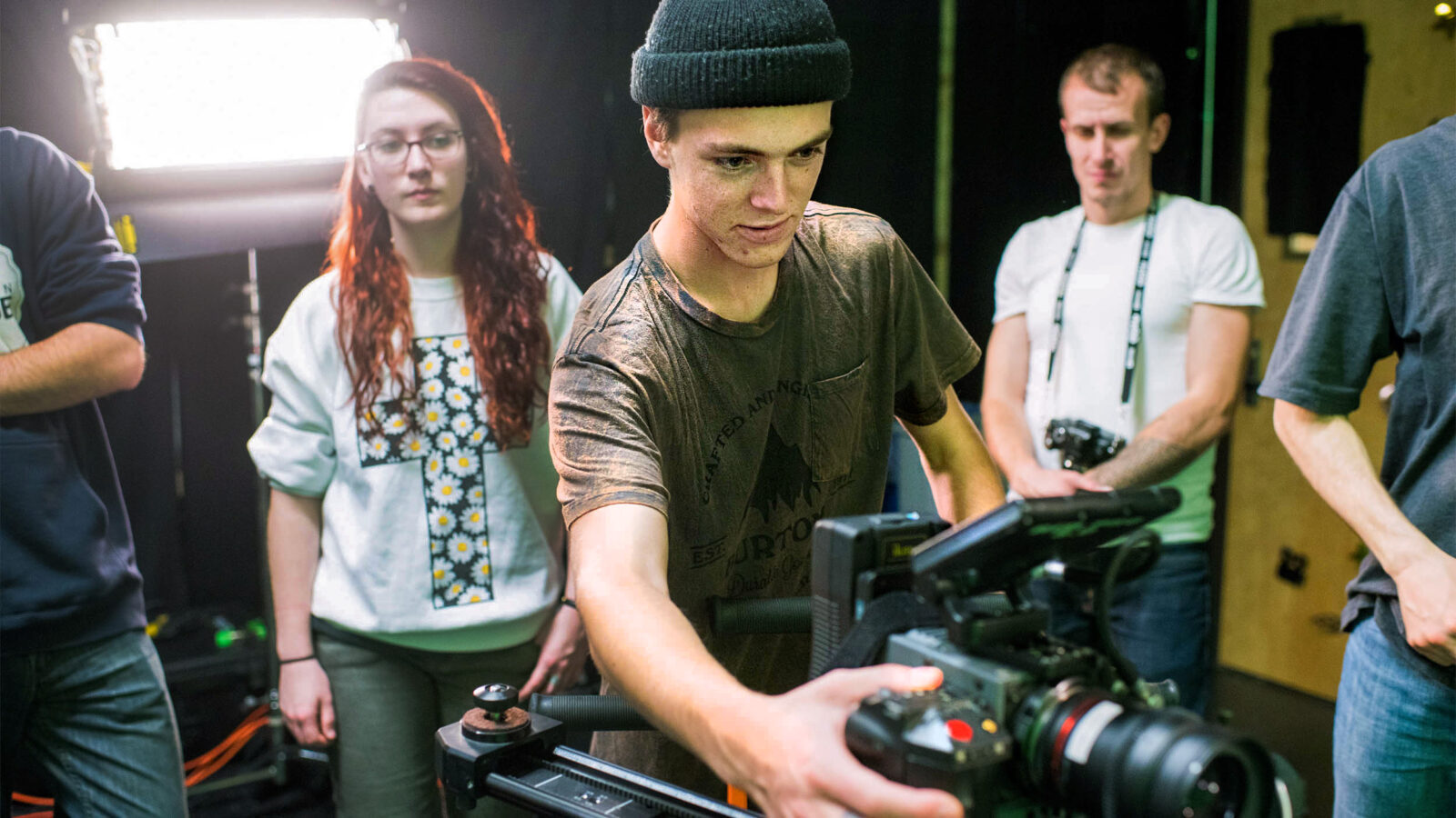student adjusts the camera in a film studio
