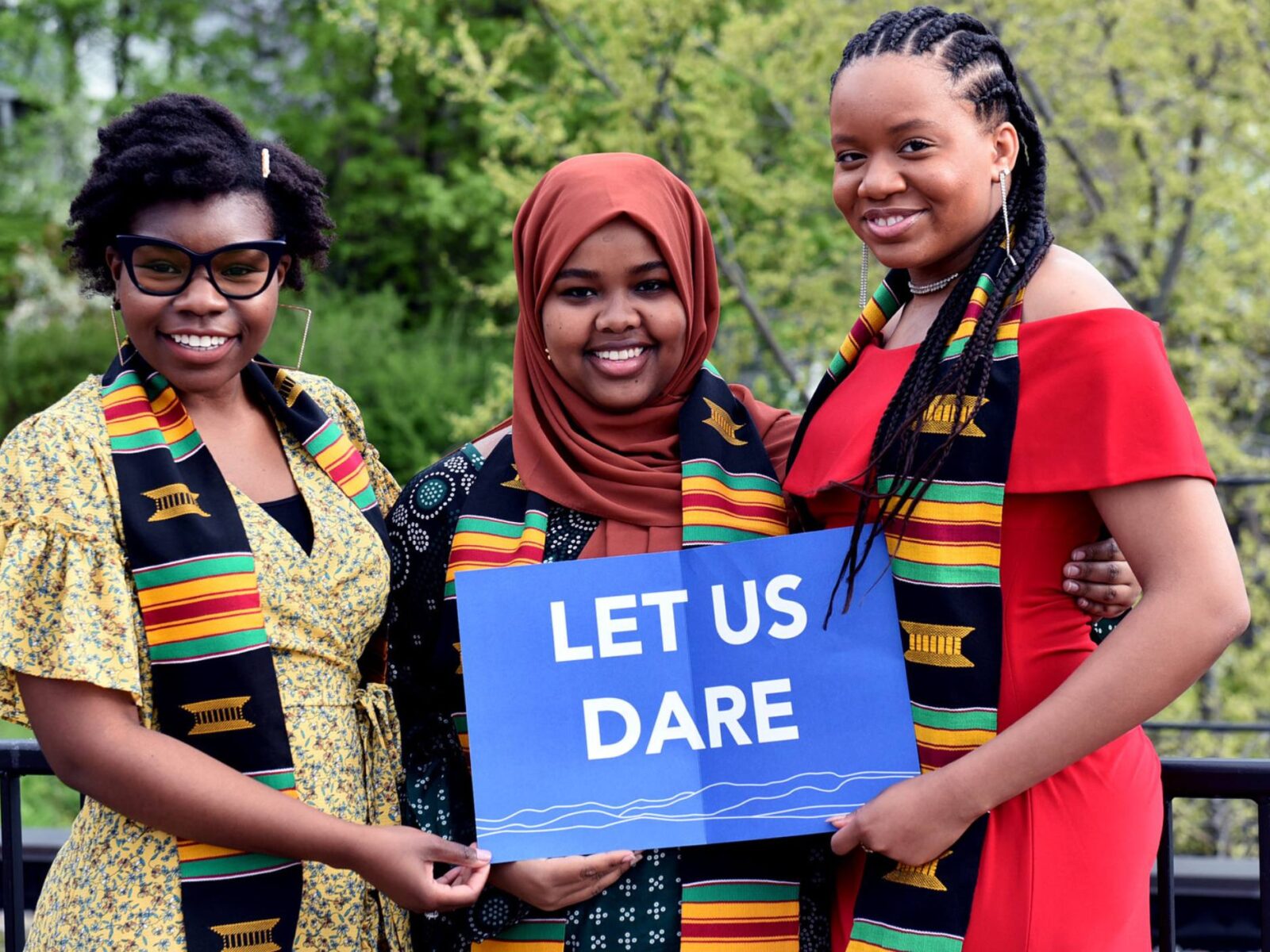 ODI Seniors stand outside firesides terrace holding a "Let us Dare" sign