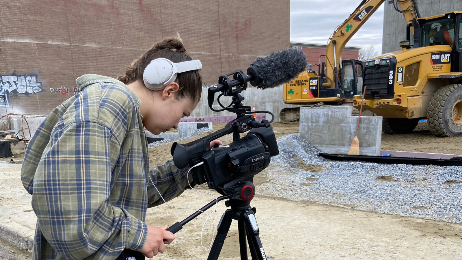 A student records a video of a construction site in downtown Burlington, Vermont