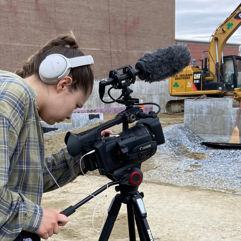 A student records a video of a construction site in downtown Burlington, Vermont