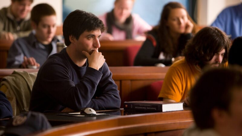 Student sitting in a classroom with others listening to a lecture