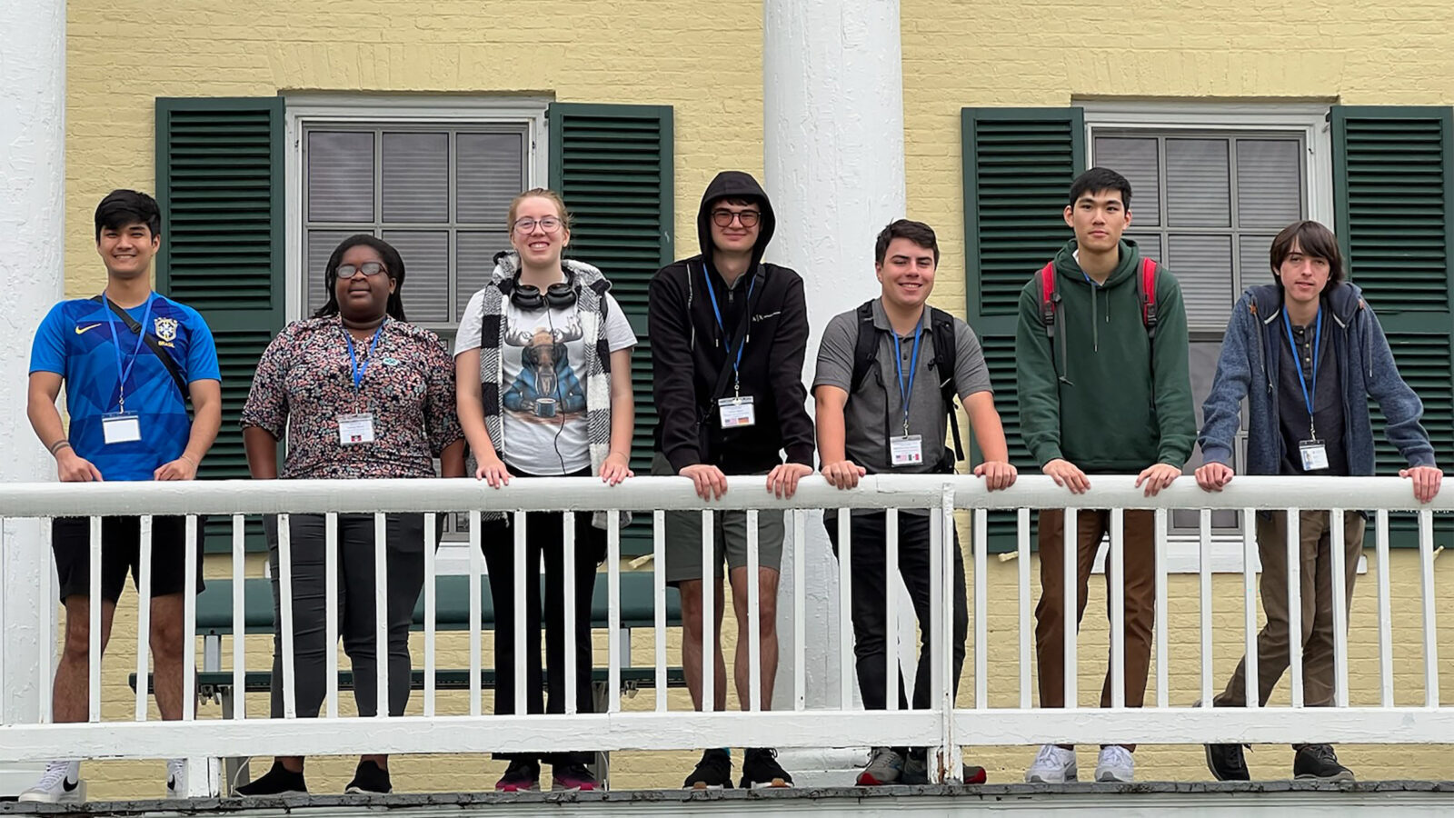 International students group photo on the front porch of an academic building