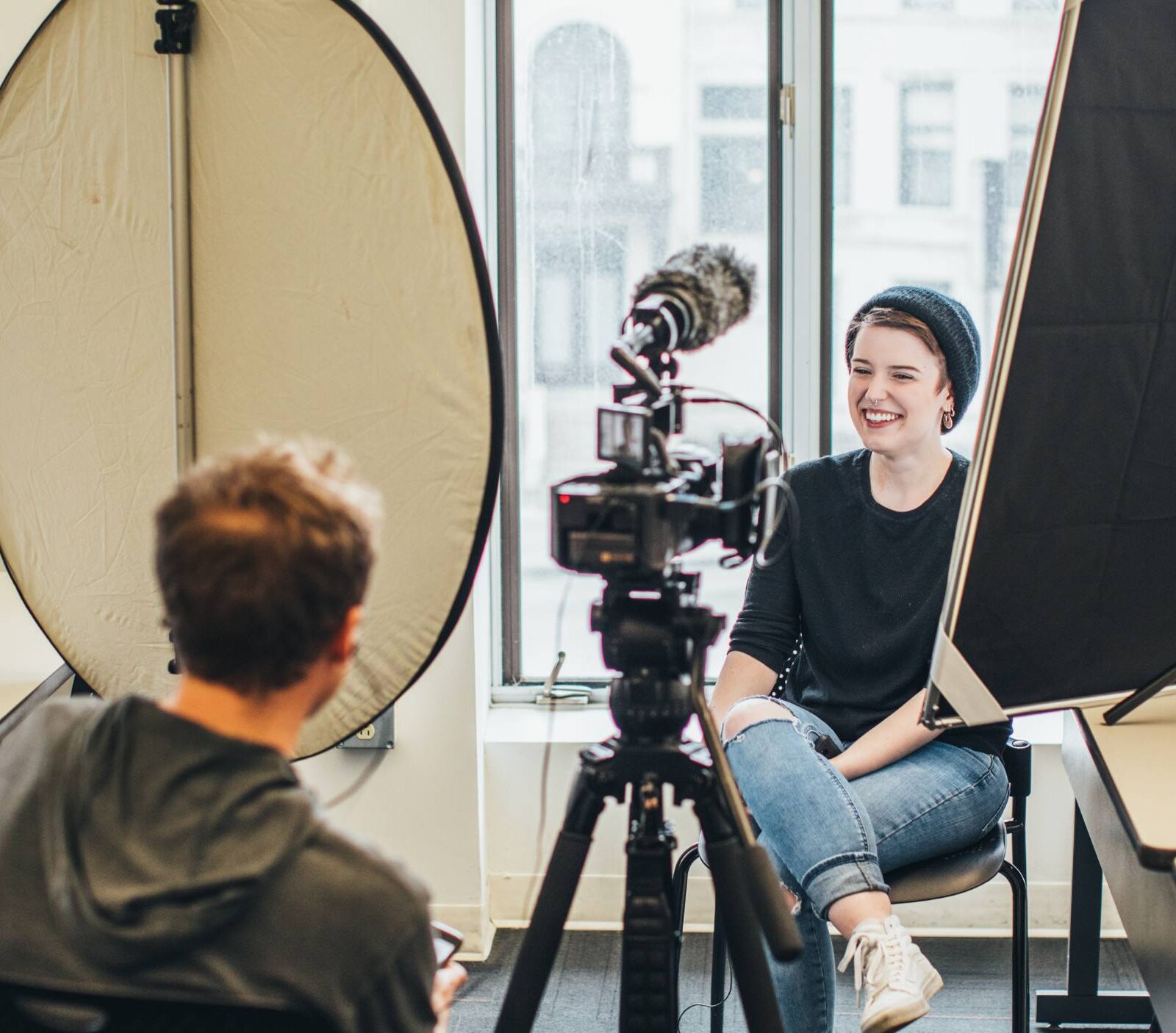 Students filming an interview in a classroom, smiling