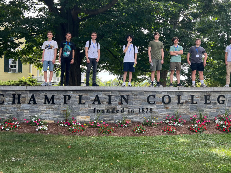 international students posing over the champlain college sign for international orientation