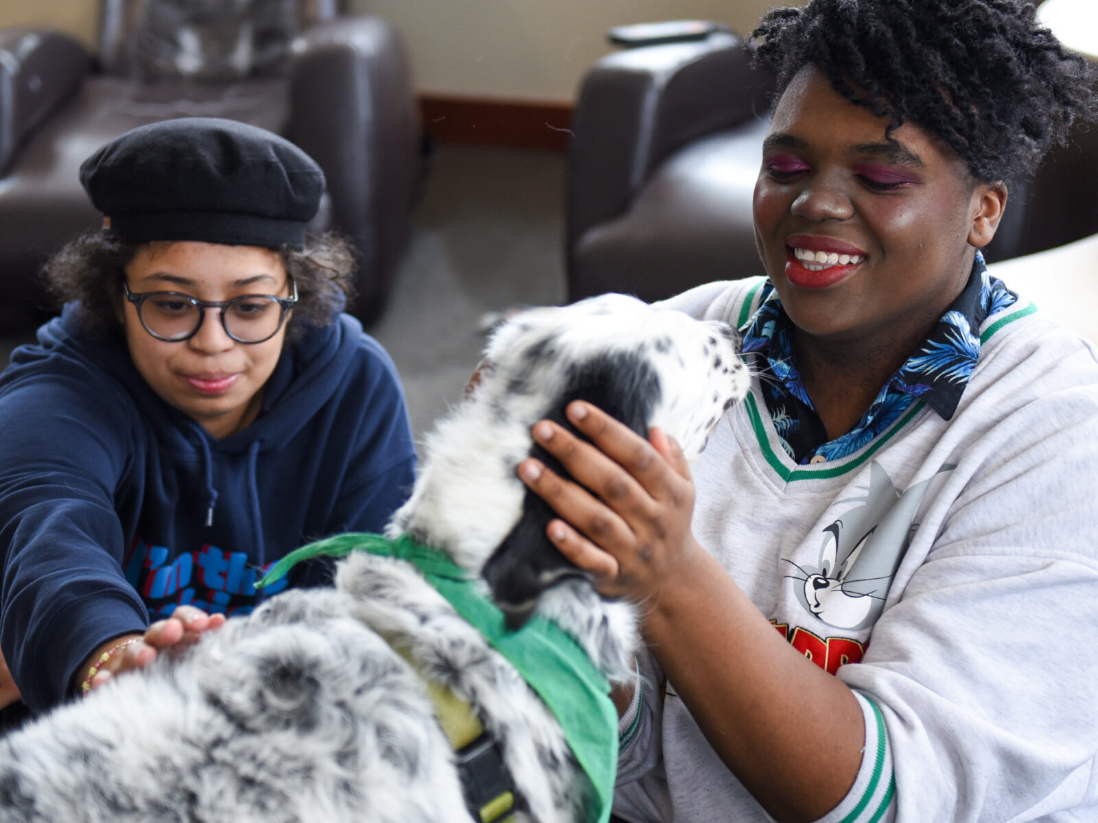 two students enjoys times with a therapy dog