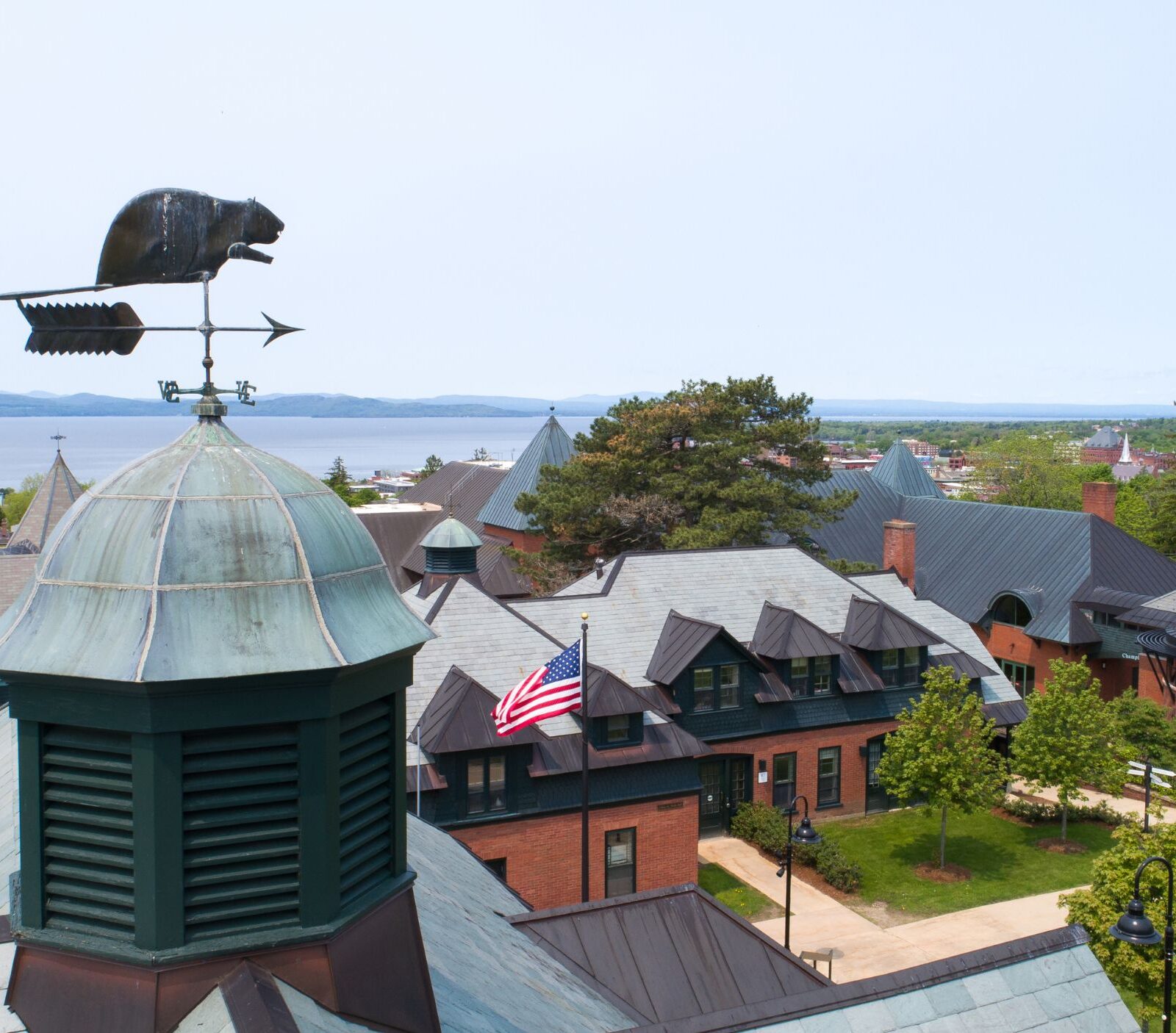 a drone photo of the beaver weather vein on top of a building on campus in the sunshine