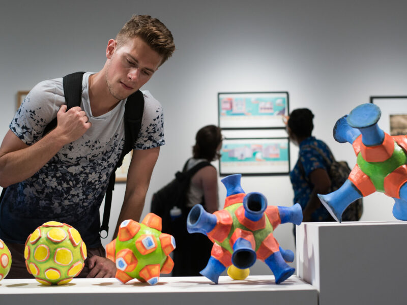 A student looking at art sculptures