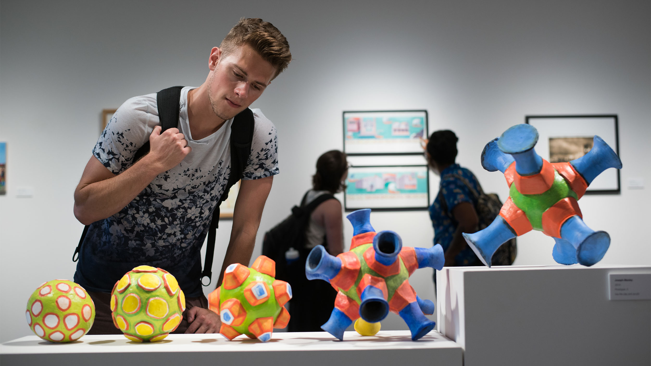 A student looking at art sculptures