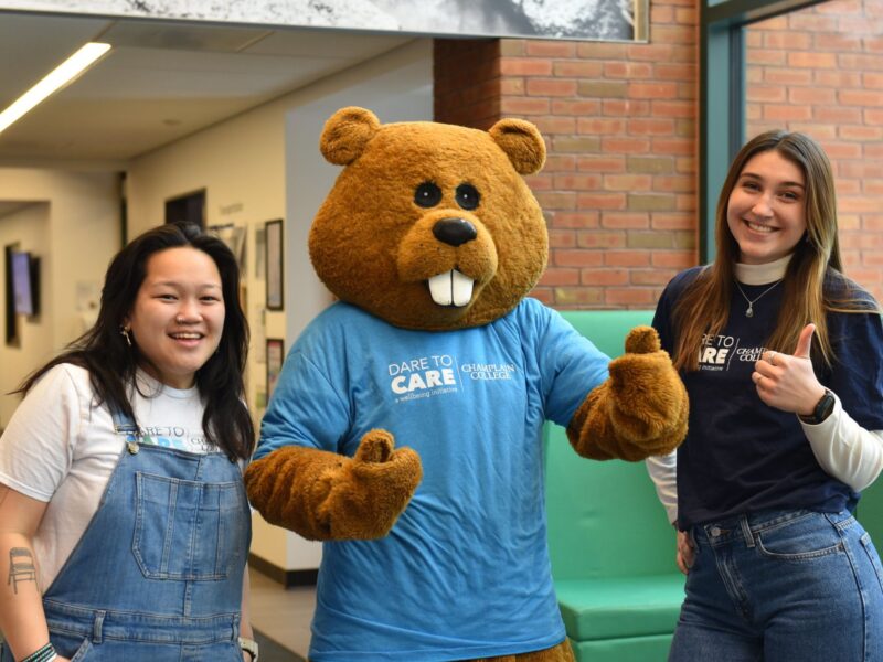 Students with Chauncey wearing a Dare to Care shirt in CCM's lobby
