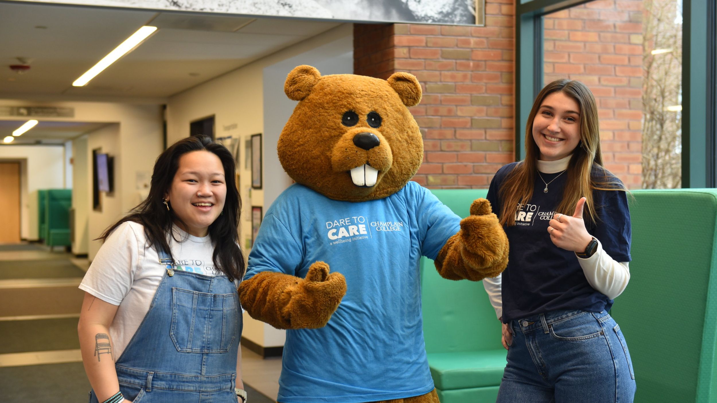 Students with Chauncey wearing a Dare to Care shirt in CCM's lobby