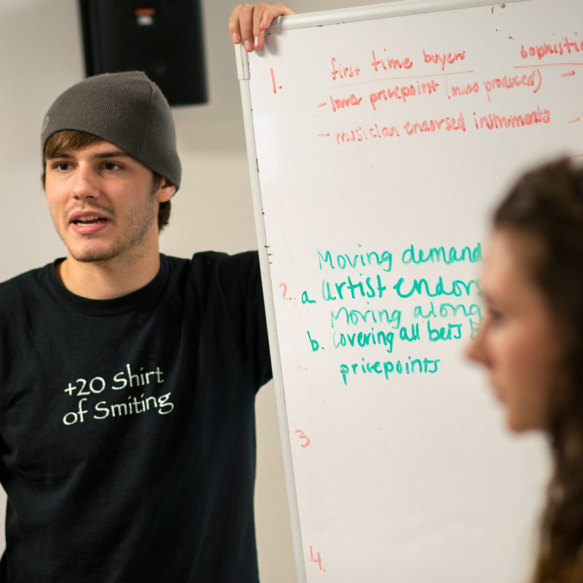 a student presents his ideas on a white board for the class to see