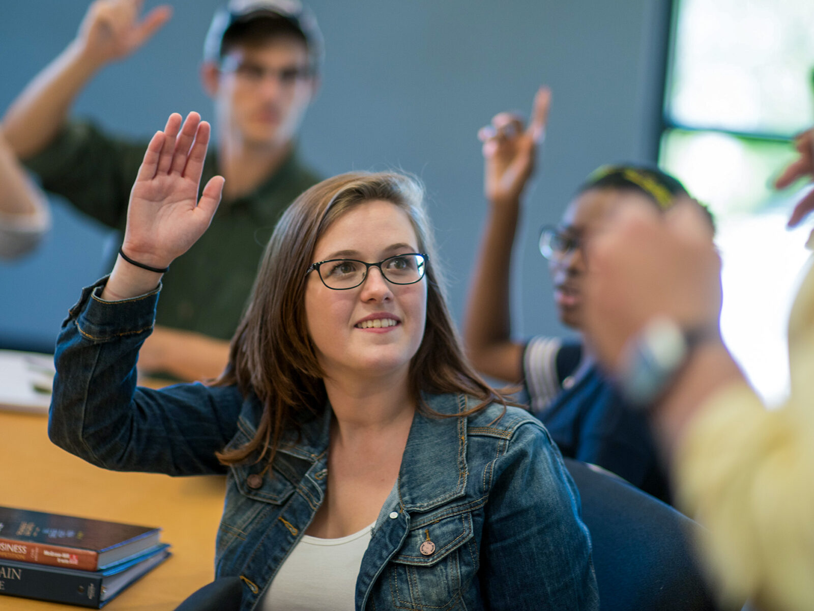 students raise their hands in class