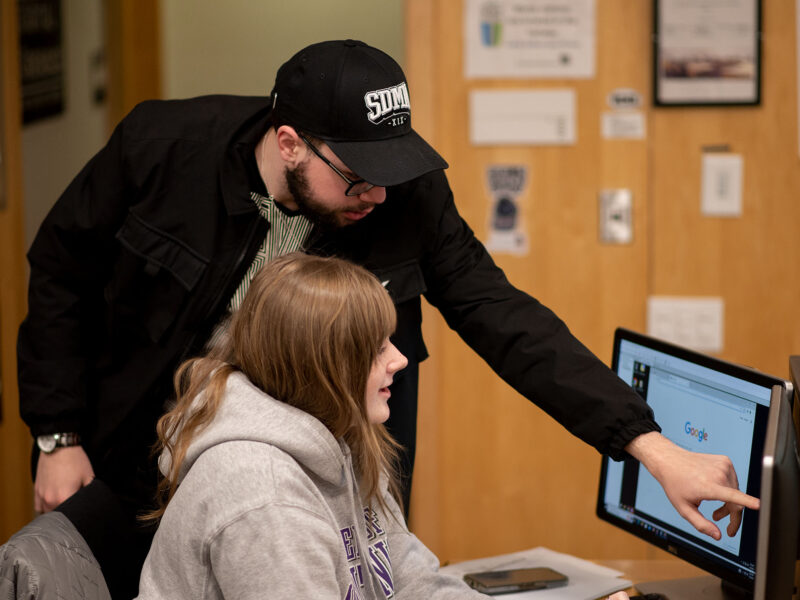 student assisting another student on the computer