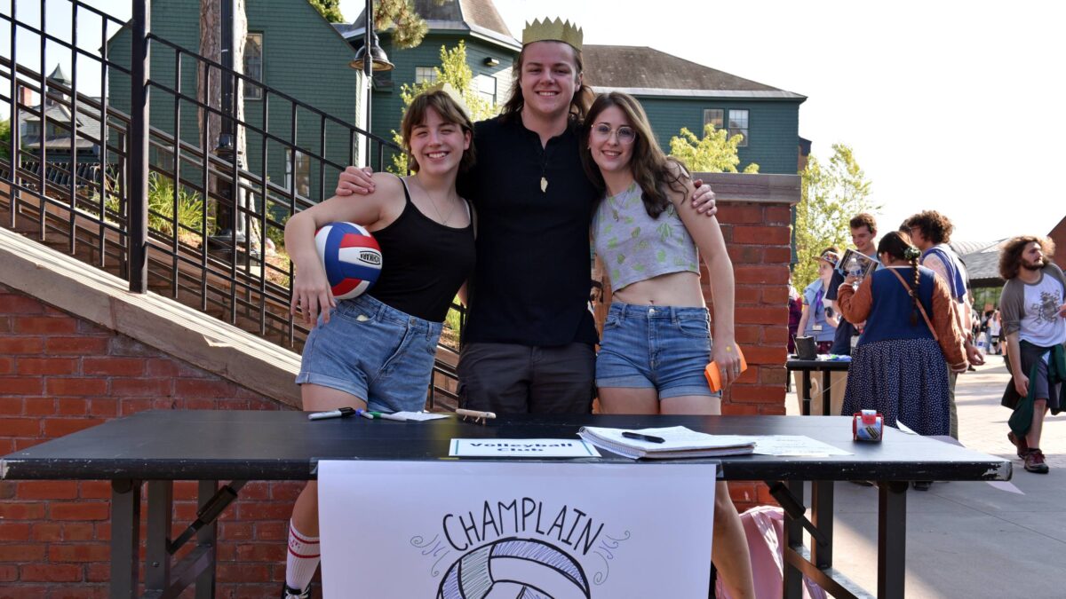 students in the volleyball club posing for a photo behind their table at the activity fair