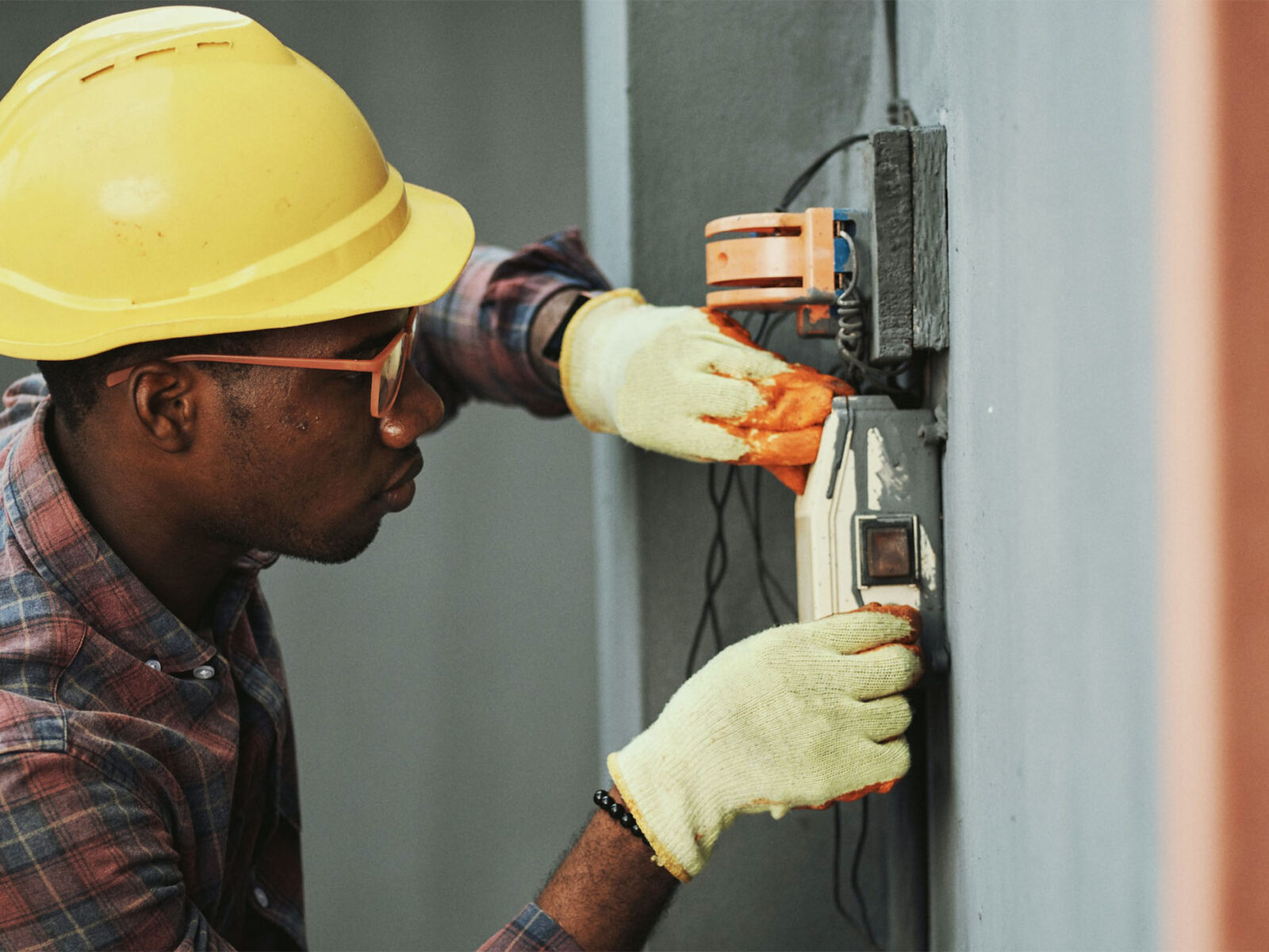 electrician working the wiring of an exterior wall